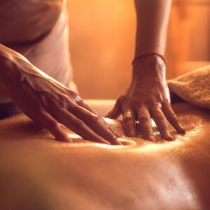 Hands massaging a person's back.