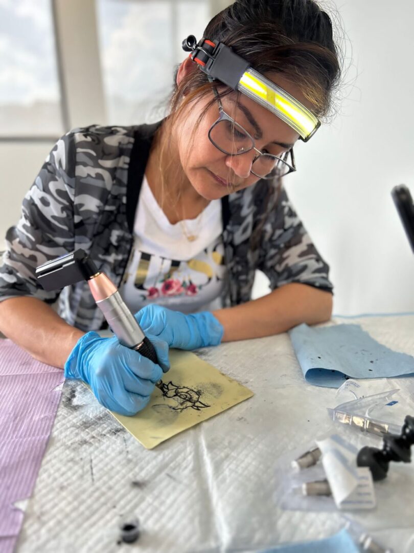 Tattoo artist practicing with a machine.