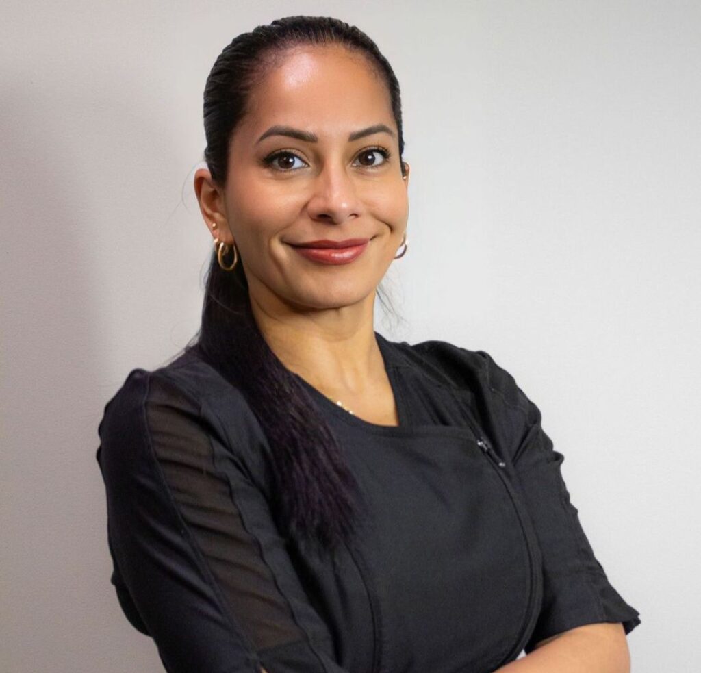 Woman with long black hair smiling.